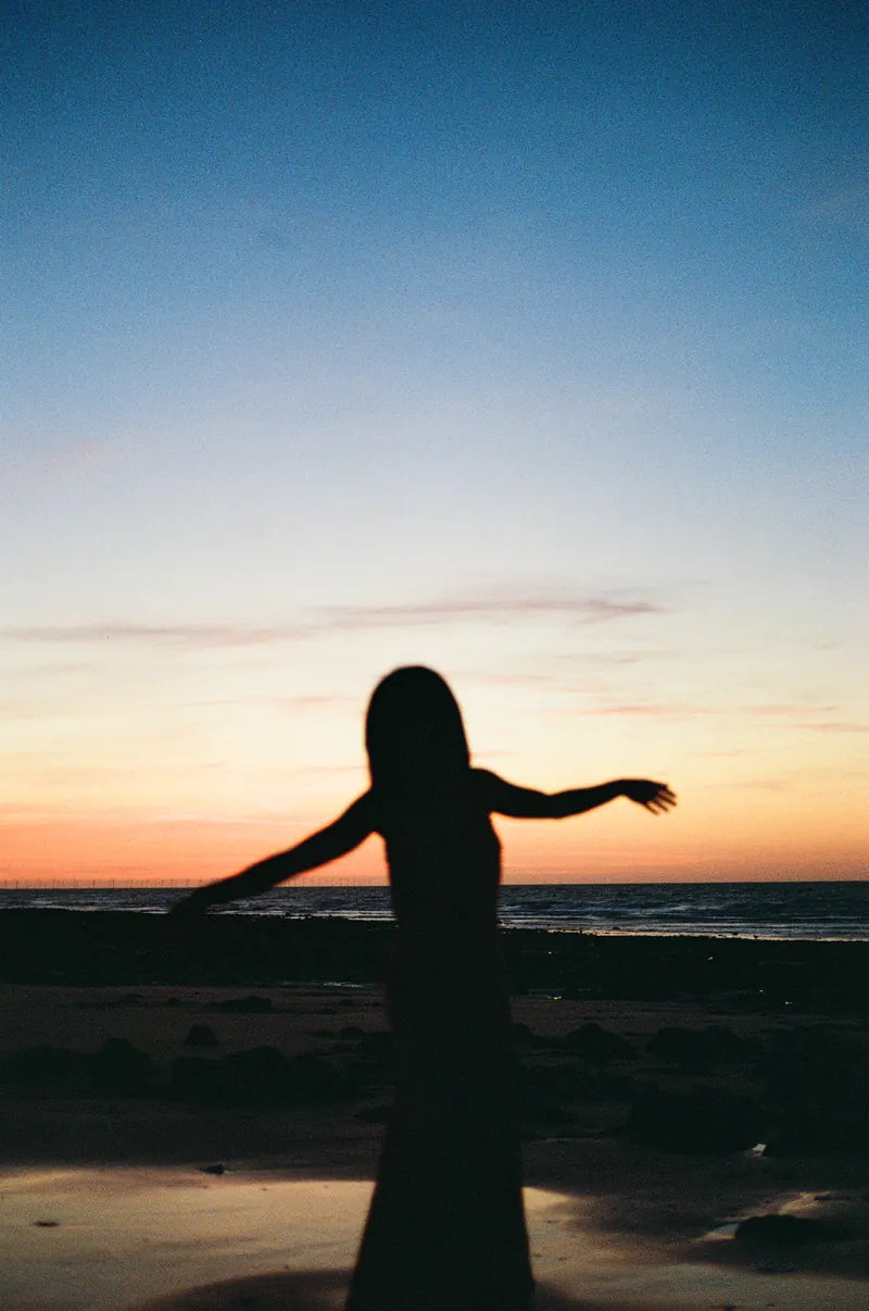 A silhouette beside the sea at sunset